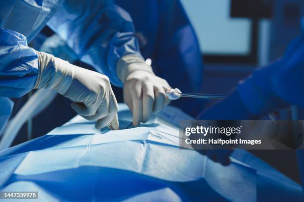 close-up of surgeon with nurse and and assistant during operation. - medical glove stock pictures, royalty-free photos & images