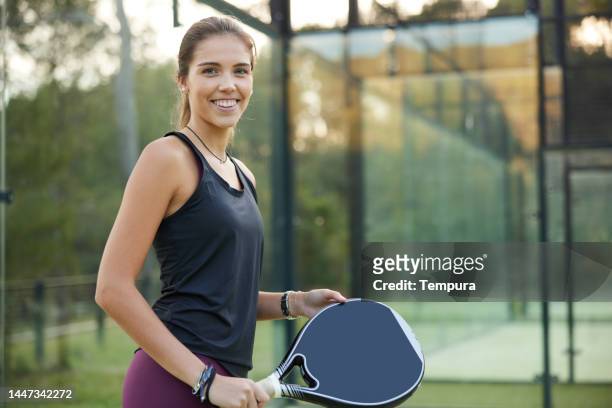 cheerful young woman with paddle tennis racket in hand - pudel stock pictures, royalty-free photos & images