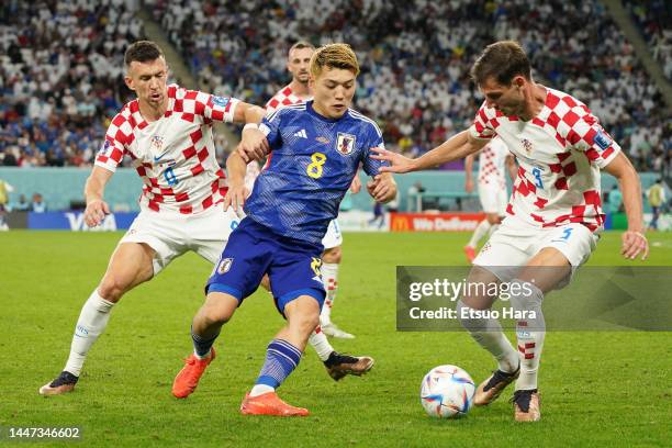 Ritsu Doan of Japan in action under pressure from Borna Barisic and Ivan Perisic of Croatia during the FIFA World Cup Qatar 2022 Round of 16 match...