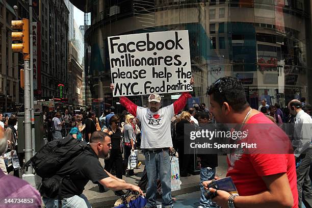 Man stands outside of the Nasdaq stock market with a sign moments after Facebook stock went public on May 18, 2012 in New York, United States. The...