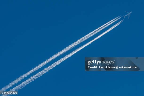 the airplane flying in the blue sky over kanagawa of japan - rastro de avião - fotografias e filmes do acervo