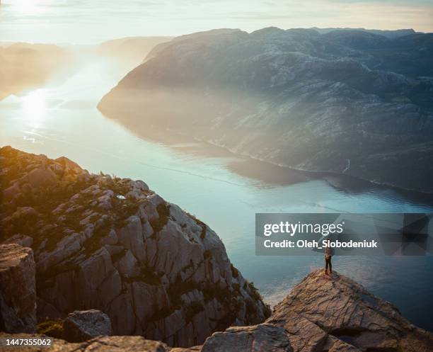 woman hiking in mountains on the background of lysefjorden - lysefjorden stock pictures, royalty-free photos & images