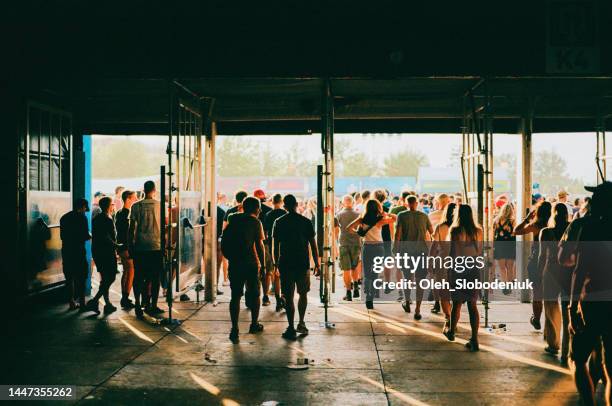 crowd of people entering music festival - ingang stockfoto's en -beelden