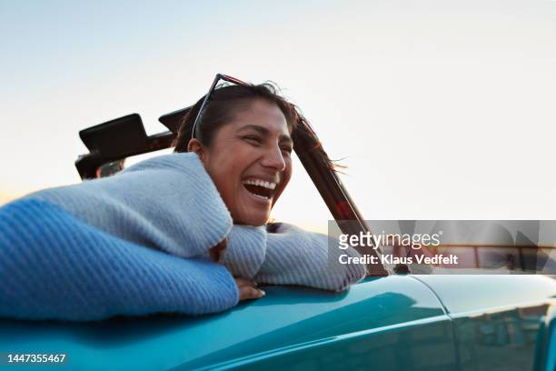 happy woman in car on road trip - life happy stockfoto's en -beelden