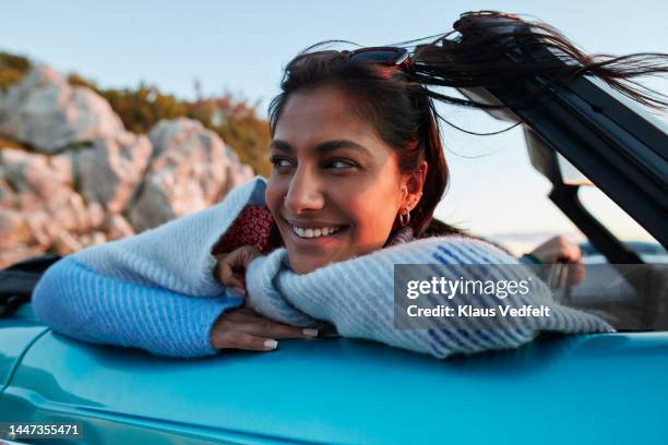 young woman leaning on car during vacation - riding car stock pictures, royalty-free photos & images