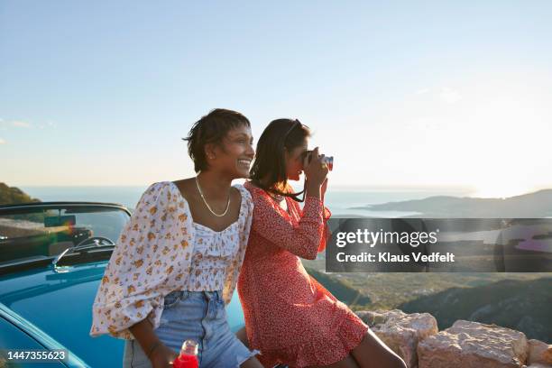 woman photographing by female friend - friendship necklace stock-fotos und bilder