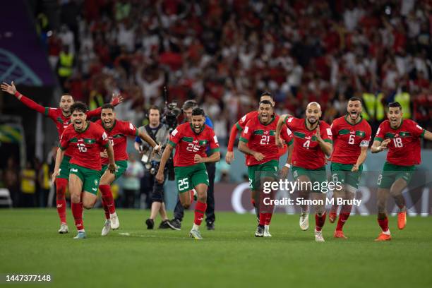 Morocco players run to winning penalty goalscorer Achraf Hakimi of Morocco and Morocco goalkeeper Yassine Bounou as they beat Spain on penalties...