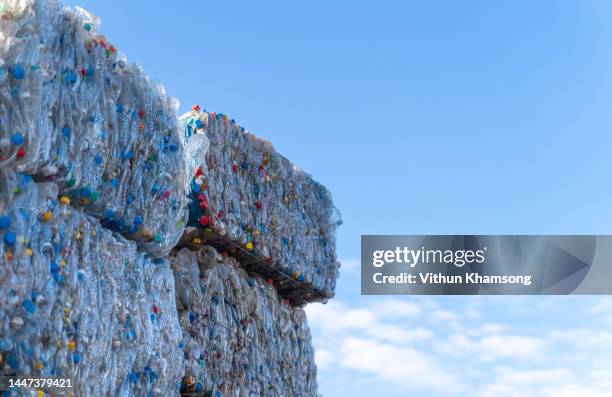 recyclable plastic materials stacked at waste sorting plant and sky - centro de reciclaje fotografías e imágenes de stock
