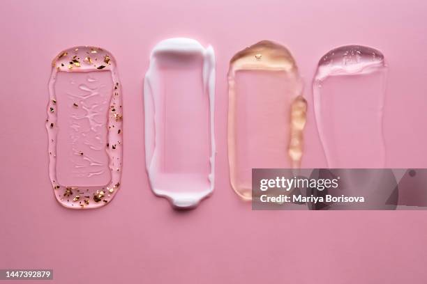 textures of different cosmetics on a pink background. - facial cleanser stockfoto's en -beelden