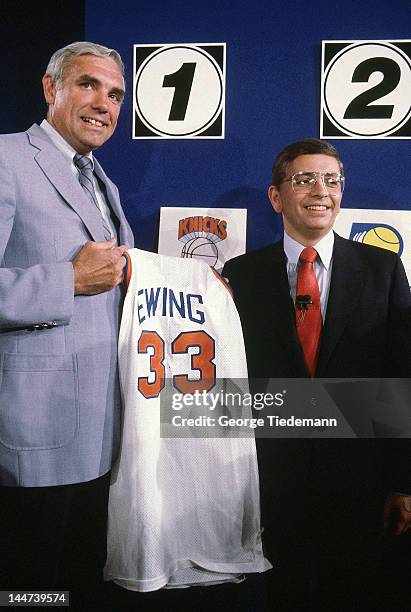 Draft Lottery: New York Knicks general manager Dave DeBusschere victorious, holding jersey reading EWING 33 with NBA commissioner David Stern after...