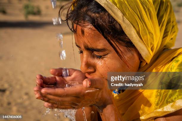 indisches junges mädchen trinkt frisches wasser, wüstendorf, rajasthan, indien - indian faces stock-fotos und bilder