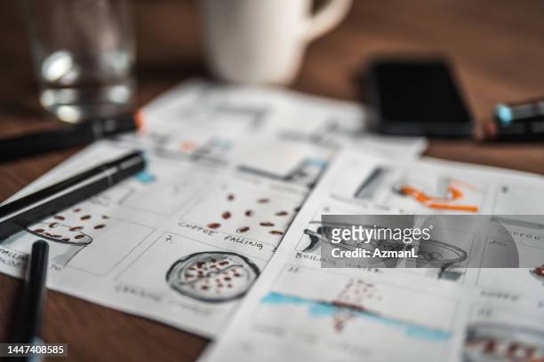 storyboard editors table; coffee, colored pencils and a smartphone - story telling in the workplace stockfoto's en -beelden