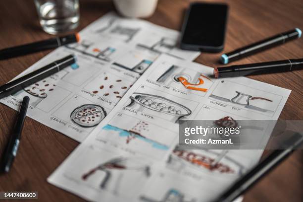 storyboard editors table; coffee, colored pencils and a smartphone - scenario stockfoto's en -beelden