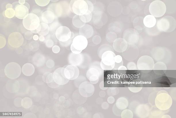 defocused image of illuminated lights white background - abstract glitter stockfoto's en -beelden