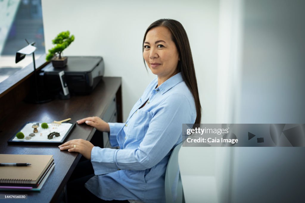 Portrait businesswoman with zen garden in office