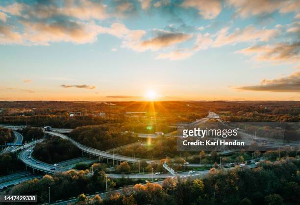 an aerial view of a multi-lane road  junction at sunset - british high street stock pictures, royalty-free photos & images