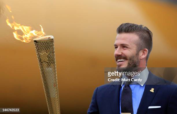David Beckham holds the Olympic Flame as it arrives at RNAS Culdrose near Helston on May 18, 2012 in Cornwall, England. The Olympic Flame arrived in...