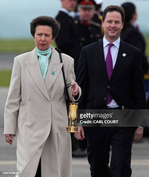 Britain's Princess Anne carries the Olympic Flame as Deputy Prime Minister Nick Clegg looks on following the flame's arrival at RNAS Culdrose air...