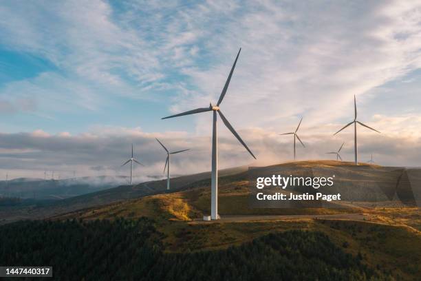 a sunset drone view of a wind farm on a hilltop in scotland - natural phenomenon stock pictures, royalty-free photos & images