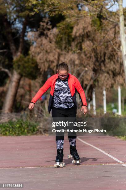 blonde girl with eyeglasses roller skating on a park - confianza stock pictures, royalty-free photos & images