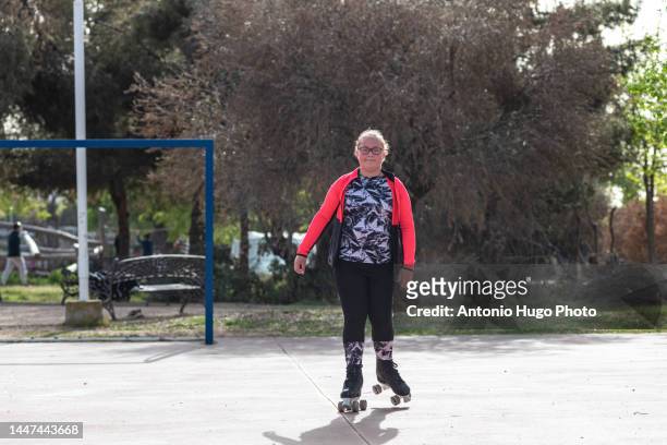 blonde girl with eyeglasses roller skating on a soccer rink - pasatiempos 個照片及圖片檔