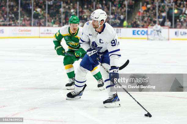 John Tavares of the Toronto Maple Leafs skates with the puck past Mason Shaw of the Minnesota Wild in the first period of the game at Xcel Energy...