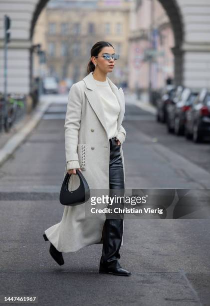 Bella Emar wears Axel Arigato creme jumper, wrstbhvr fake leather pants, Ysl sunglasses , Coperni bag , creme white Nikkie coat on December 06, 2022...