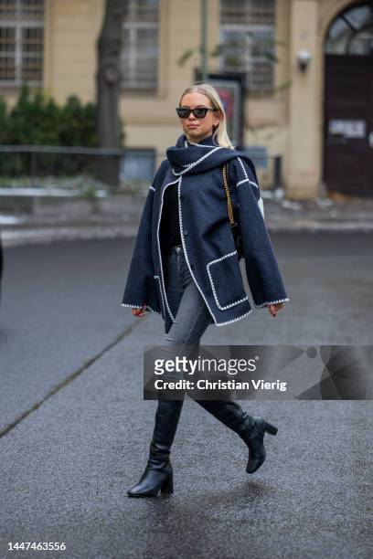 Kristin wears navy white jacket Toteme, denim jeans in grey Topshop, boots Zara on December 06, 2022 in Berlin, Germany.