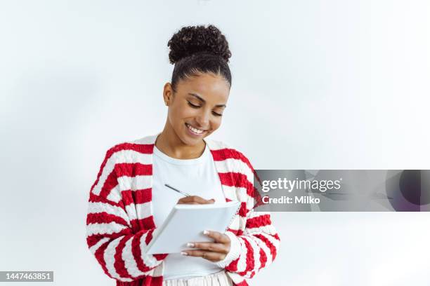 beautiful woman writing to do list - christmas list stock pictures, royalty-free photos & images