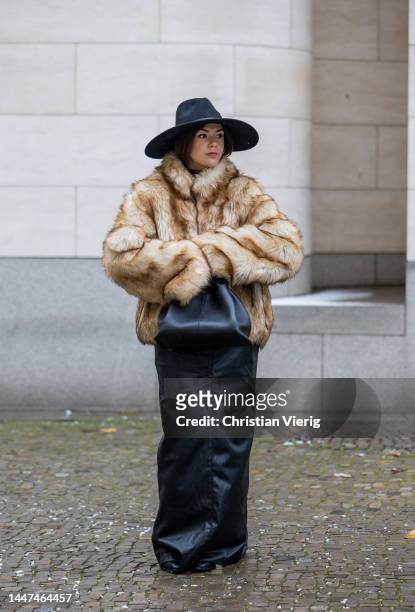 Amelie Stanescu wears beige Gant faux fur coat, Zara skirt, Flattered shoes, Twin Set fedora hat, Polene Paris bag on December 06, 2022 in Berlin,...