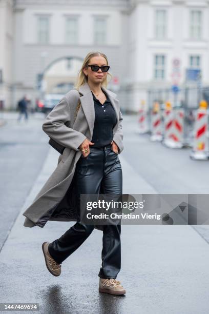 Kristin wears grey coat Mango, beige boots Inuikii, black pants Zara, YSL bag on December 06, 2022 in Berlin, Germany.