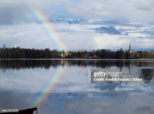 scenic view of rainbow over lake against sky - vår stockfoto's en -beelden
