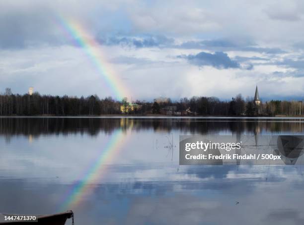 scenic view of rainbow over lake against sky - väder stock pictures, royalty-free photos & images