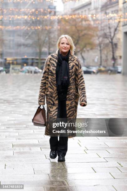 German TV presenter Ulla Kock am Brink wearing a long beige and black fuzzy animal tiger print coat by Zadig & Voltaire, a black scarf by Zadig &...