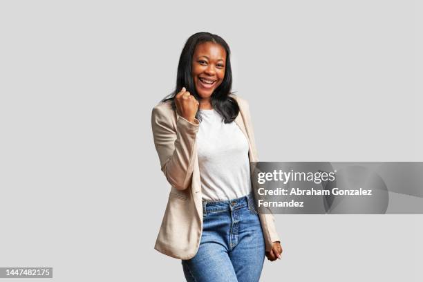 african woman celebrating while gesturing with her fist - you can do it stock pictures, royalty-free photos & images