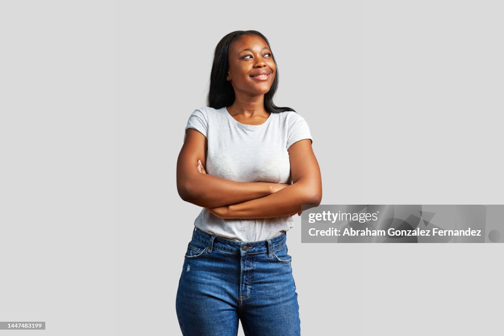 Dreamy african woman looking up with her arms crossed