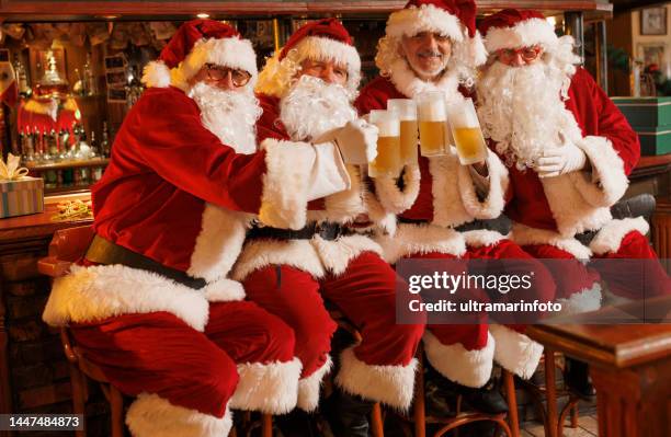 portrait of four traditional santa claus on christmas.  drinking beer in retro pub. - pub mates stock pictures, royalty-free photos & images