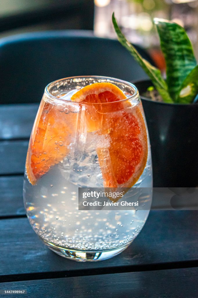 Glass of lemonade with slices of grapefruit and ice.