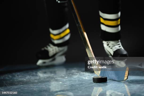hockey player in sports uniform and skates standing with stick in his hands. - hockeystick sportartikelen stockfoto's en -beelden