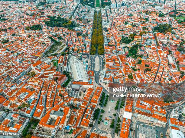 overhead top down birds eye aerial view of patterns of red rooftops of traditional houses with narrow streets in lisbon city center - lissabon stockfoto's en -beelden