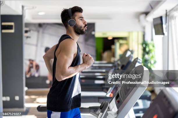 ein junger mann läuft auf einem laufband in einem fitnessstudio. - athlete training urban gym stock-fotos und bilder