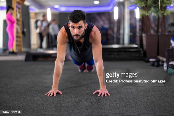 a young handsome man is doing push-ups in a gym. - workout bench stock pictures, royalty-free photos & images
