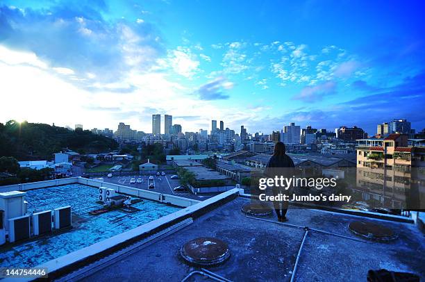 woman standing on top of building - taipeh gegenlicht stock-fotos und bilder