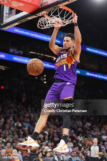 Devin Booker of the Phoenix Suns slam dunks the ball against the Boston Celtics during the second half of the NBA game at Footprint Center on...