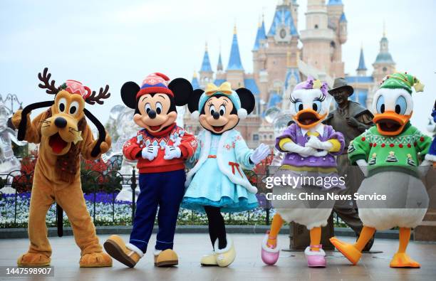 Disney characters pose for photos to welcome visitors, marking the Shanghai Disney Resort' return to full operations on December 8, 2022 in Shanghai,...