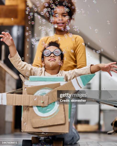 carefree black girl pretending to be a pilot at home. - pretending to be a plane stockfoto's en -beelden