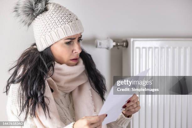 yound woman is shocked from the rising energy costs and the bill she received for heat and electricity for her household. - electricity bill stockfoto's en -beelden