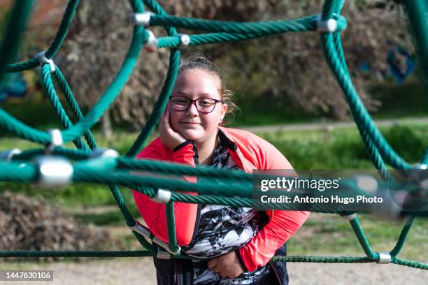 portrait of a blonde girl with eyeglasses in a playground pyramid rope. - buxom blonde stock pictures, royalty-free photos & images