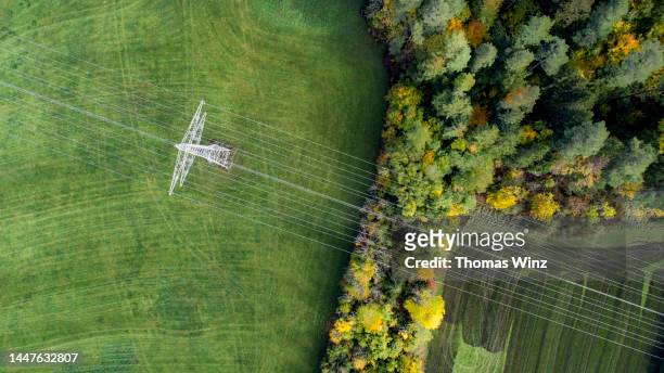 electrical pylon and wires in an agricultural field from above - power cable bildbanksfoton och bilder