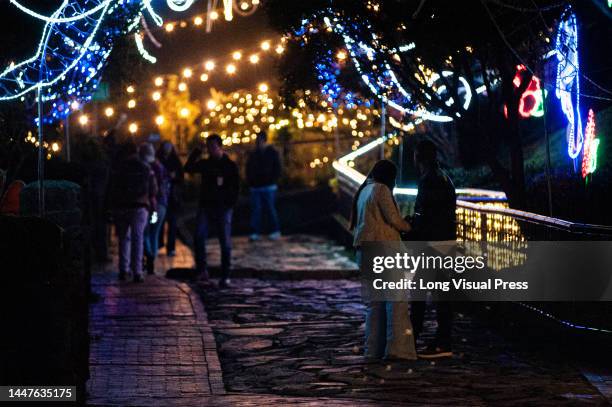 People enjoy the christmas lights of the Monserrate church landmark in Bogota, Colombia on December 3, 2022. The christmas light decorations aim to...